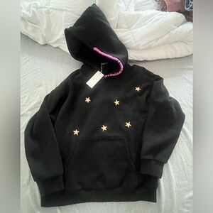 Black hoodie with purple stitching and yellow gold stars. Hand made design.